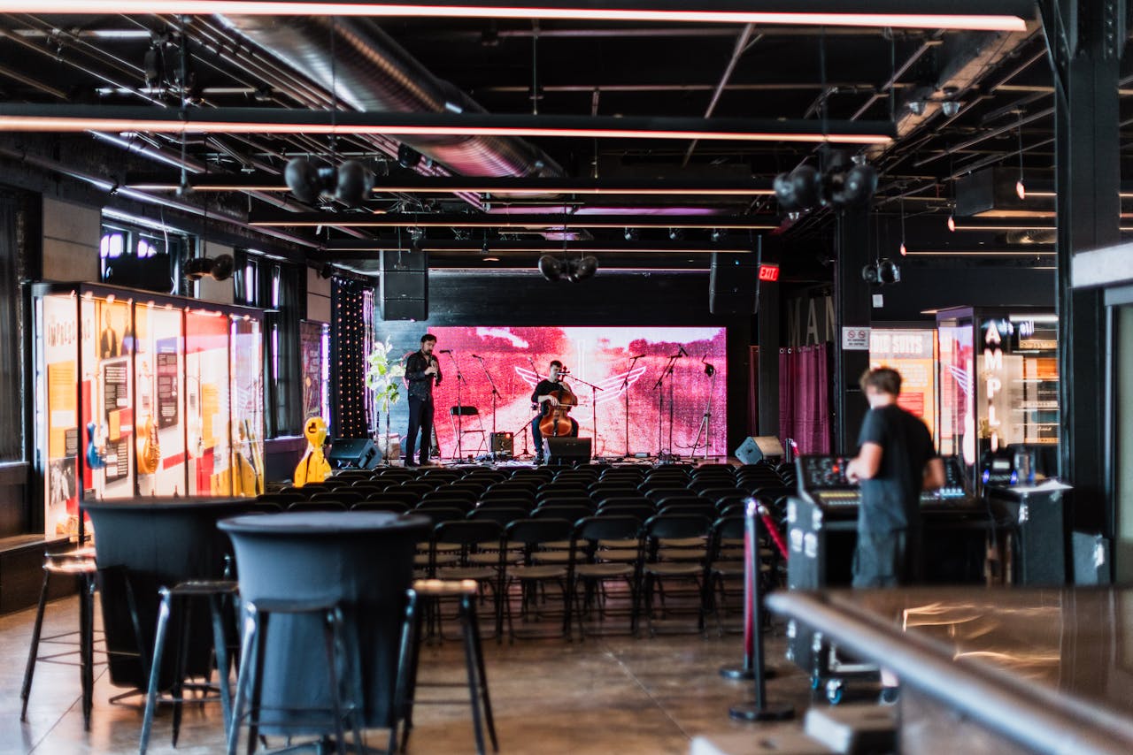 Musicians preparing on stage in an empty music venue, ready for a concert.